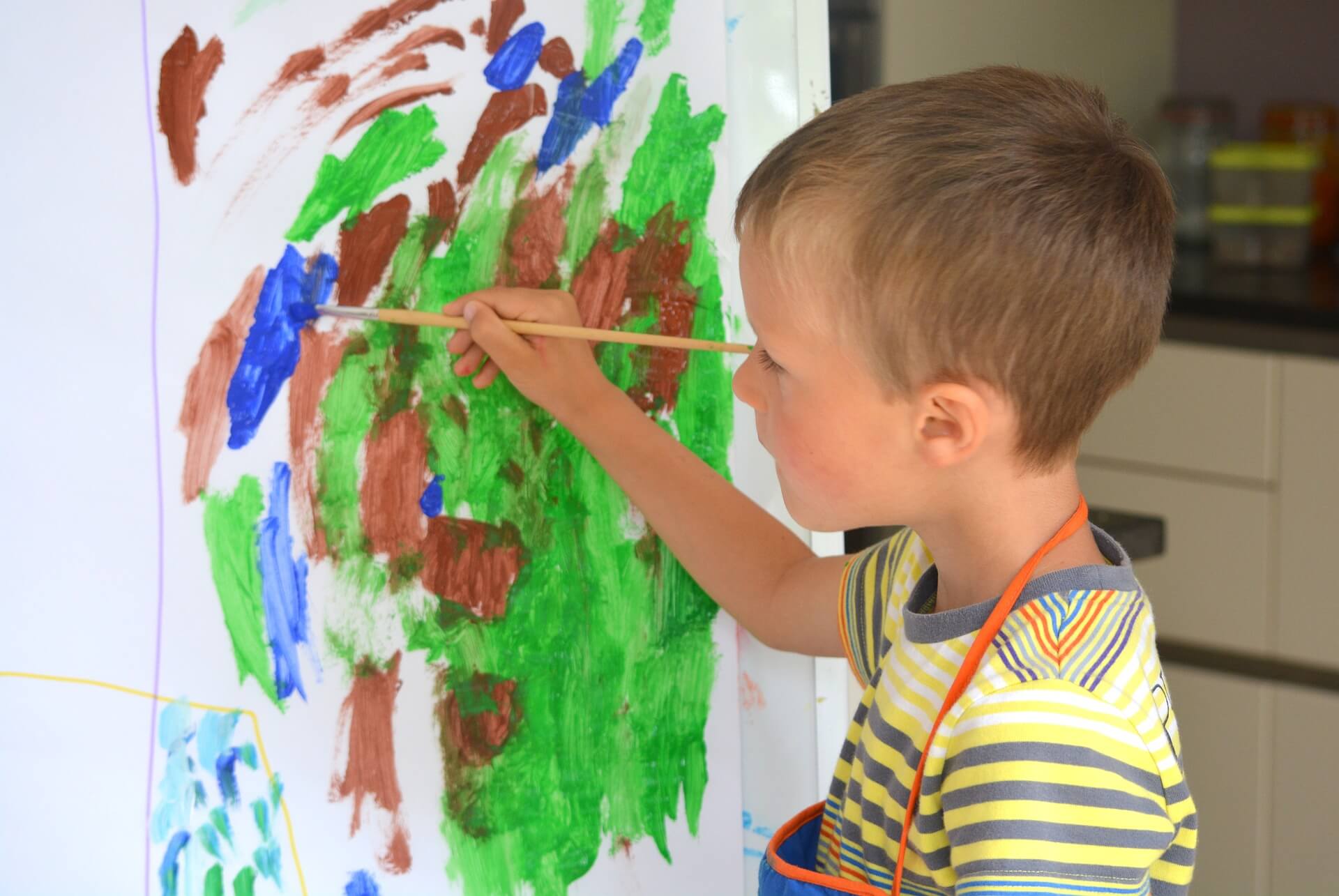Junge der mit Wassermalfarben malt